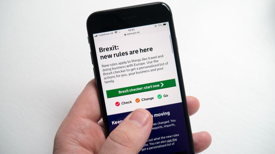 Image of a hand holding a smartphone. The view is a closeup of the screen that show the GOV.UK page for Brexit. It reads: Brexit: new rules are here