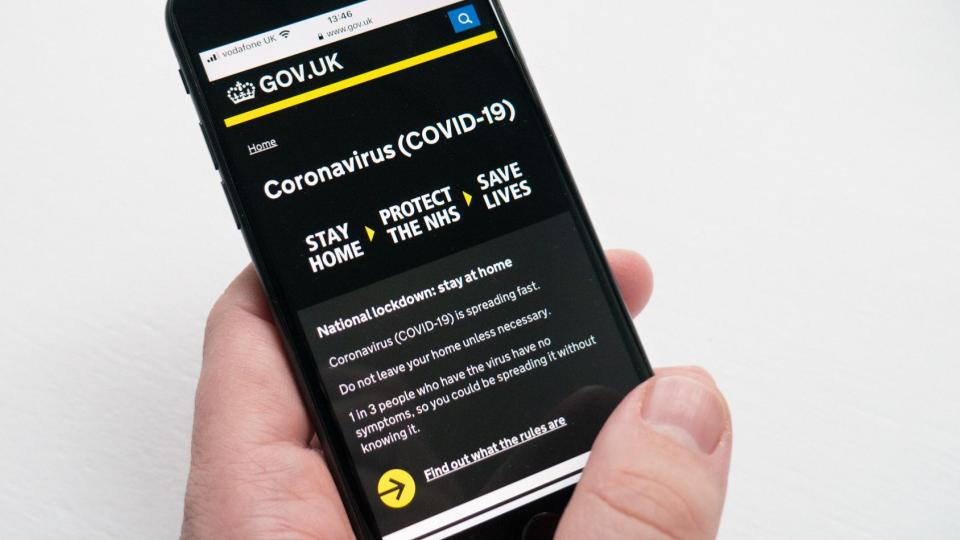 Image of a hand holding a smartphone, zoomed into the screen. On the screen there is the GOV.UK coronavirus page dedicated to providing information, guidance and support for coronavirus 